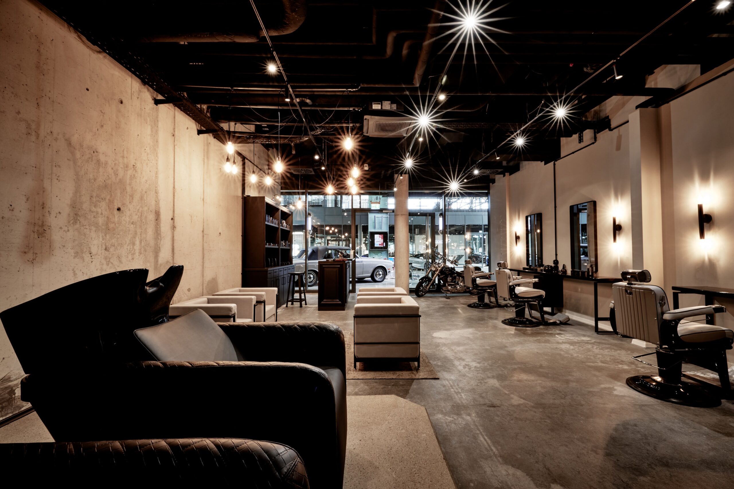 Die M-Crew Friseure Hallbergmoos: An ihrem Standort in der Motorworld München scheiden die Hairstylisten zwischen McLaren und Bugatti trendige Bärte und Frisuren.