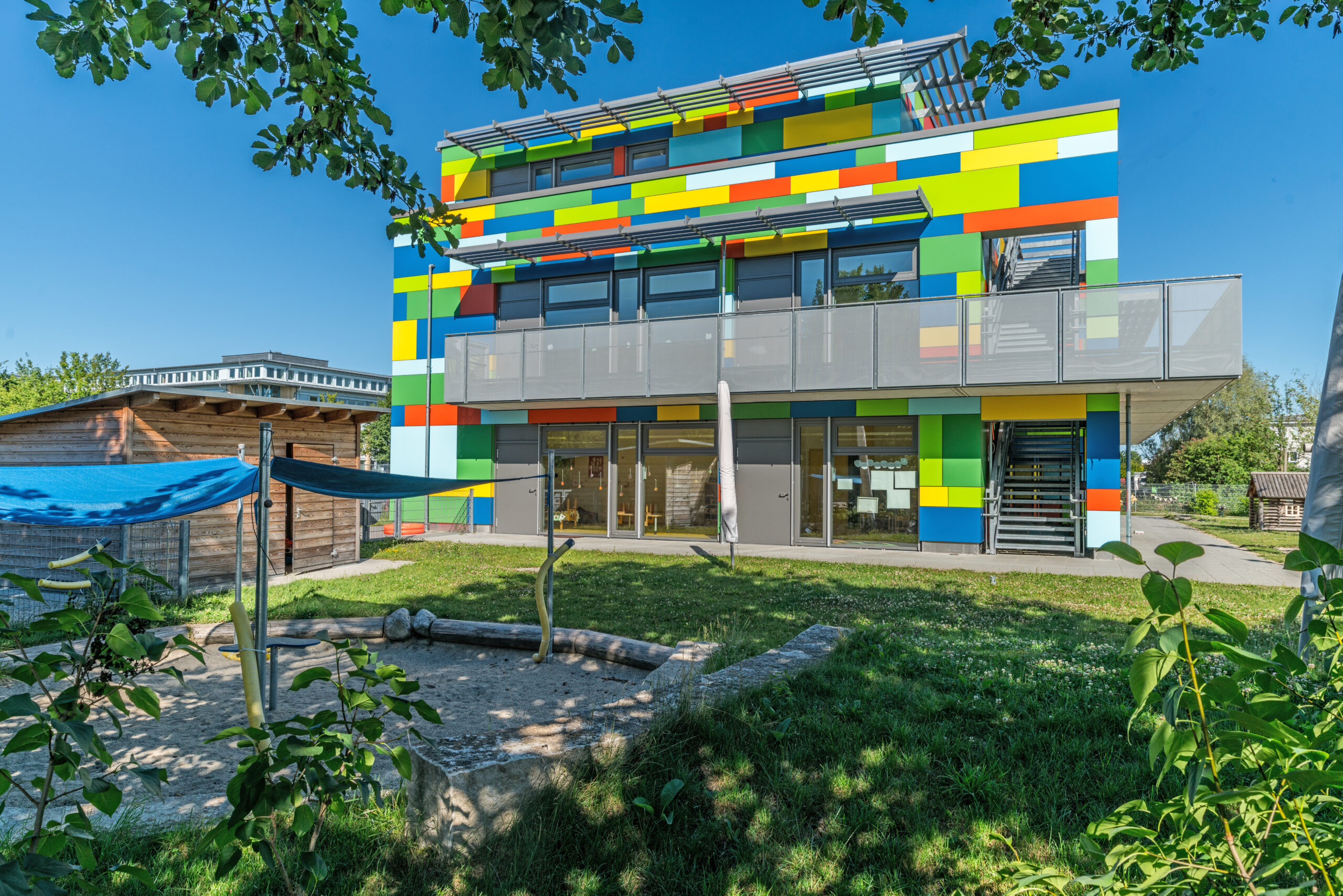 Manfred Zentsch dokumentiert das bunte, moderne Gemeindegebäude in Hallbergmoos mit farbiger Fassadenverkleidung, Glasfronten und Außenbereich