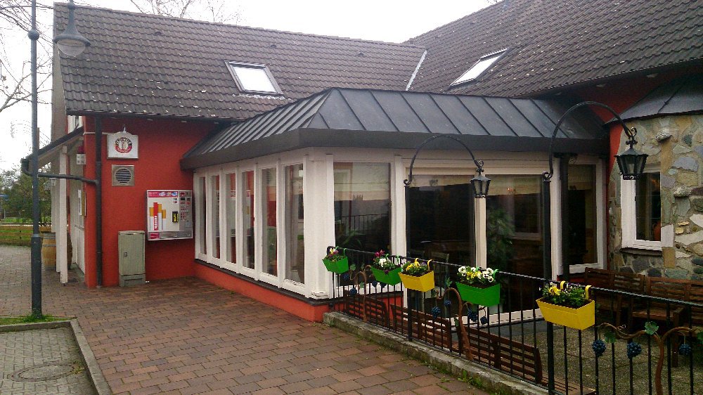 Ein Gebäude mit einem modernen Anbau und großen Fenstern, das eine einladende Atmosphäre vermittelt.