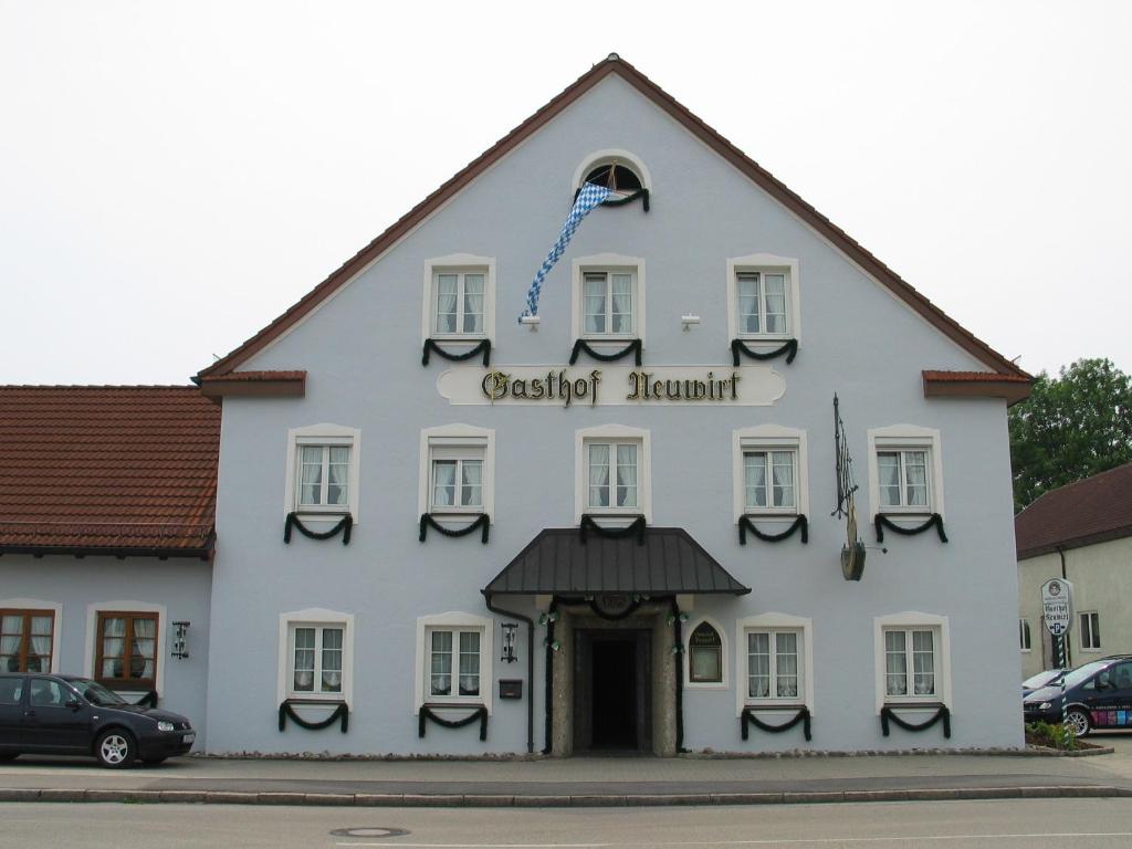 Gasthof Neuwirt in Hallbergmoos mit traditioneller Fassade und mehreren Fenstern.