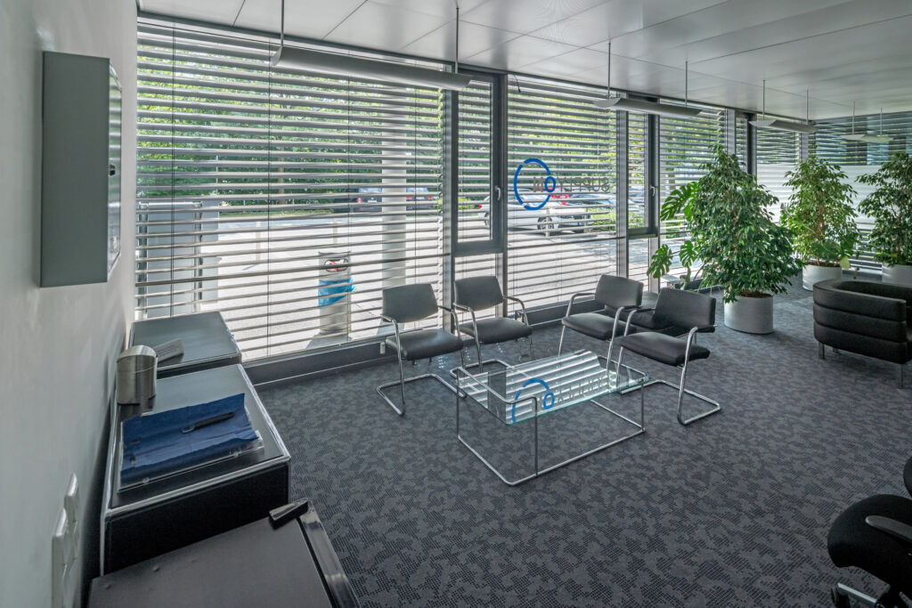 Moderne Wartebereich mit Stühlen und Glastisch in einem Bürogebäude.