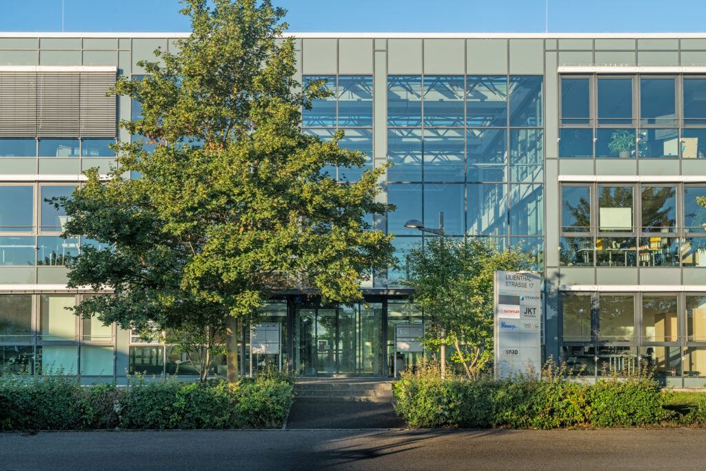 Moderne Bürogebäude mit Glasfassade und Eingangsbereich in München.