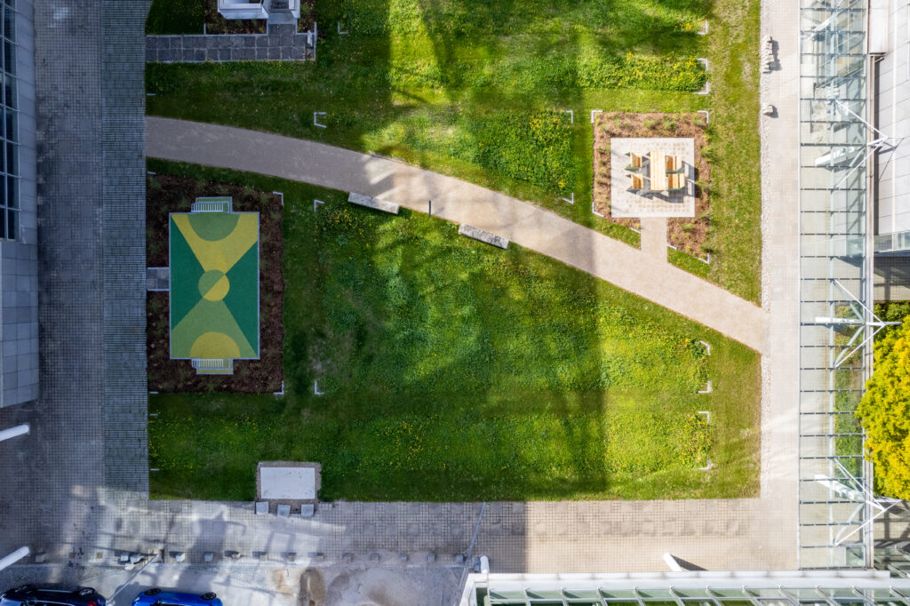 Grünfläche mit einem Tisch und Stühlen im MABP, München, aus der Vogelperspektive.