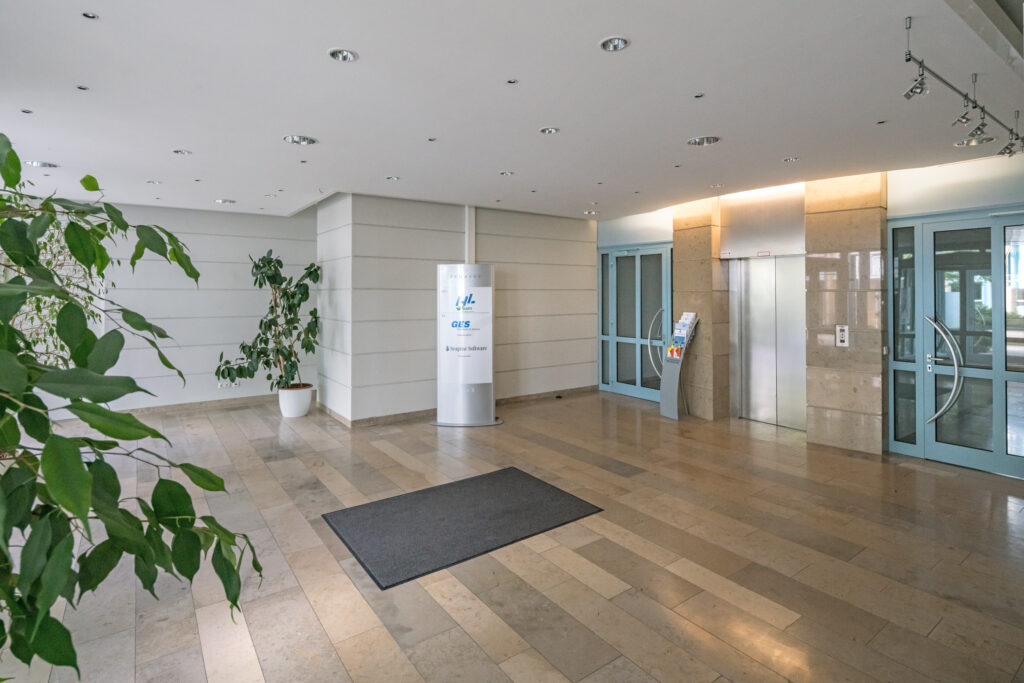 Eingangsbereich des MABP mit Aufzug und Pflanzen im Innenraum.