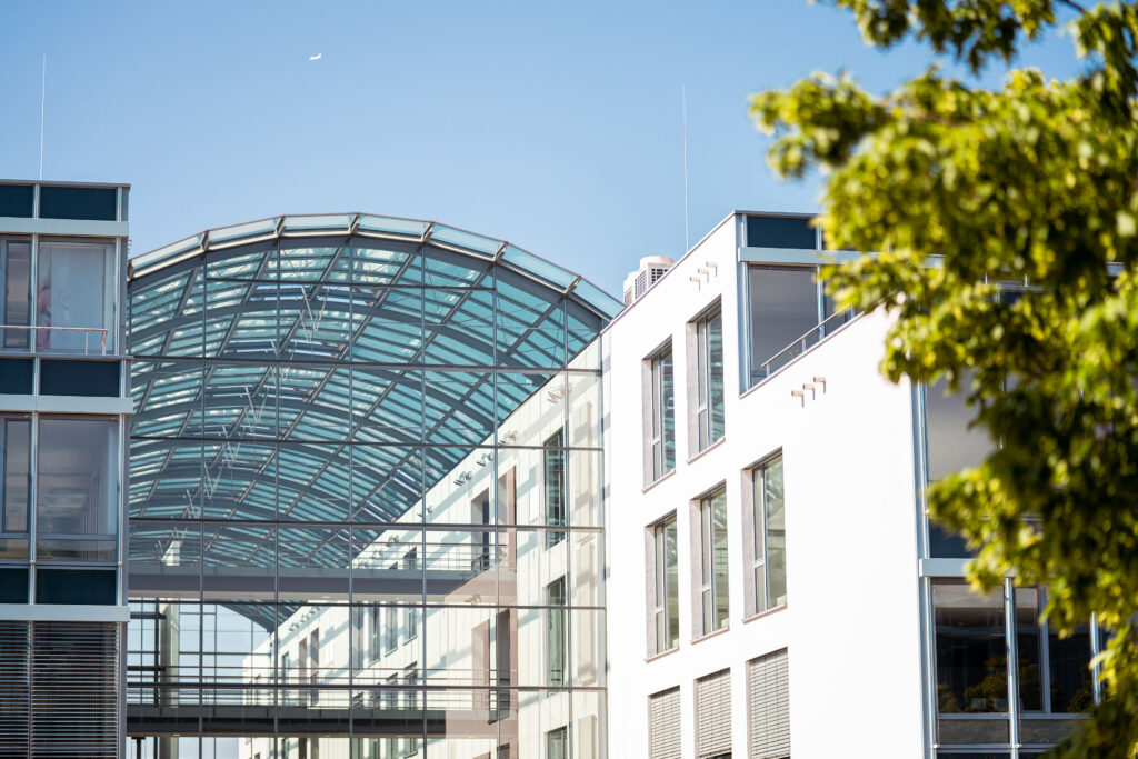 Moderne Architektur eines Gebäudes mit Glasdach und weißen Wänden im Munich Airport Business Park.