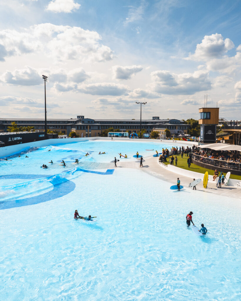 Surftown mit Wellenbecken und Surfern in einem Freizeitbereich.