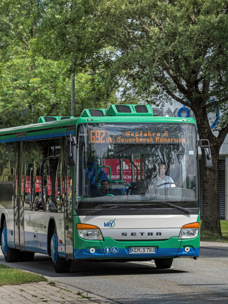 Ein Setra-Bus der Linie 692 mit Ziel Gewerbepark Römerweg fährt auf einer Straße.
